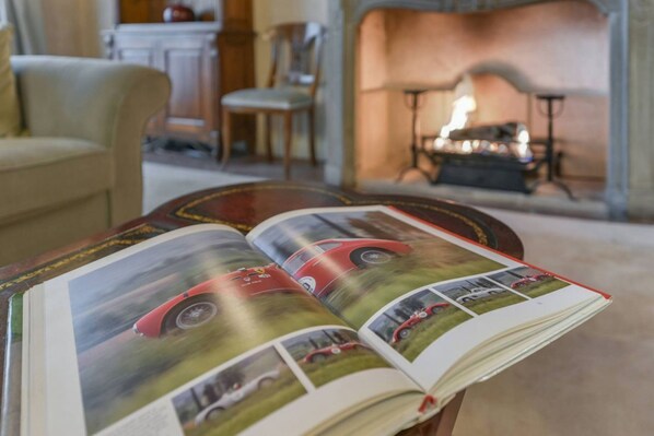 An open book with a red car on the cover, placed on a wooden table in a room with a fireplace. - Spacious apartment with a fireplace in Pontormo, in the Oltrarno neighborhood (Firenze)