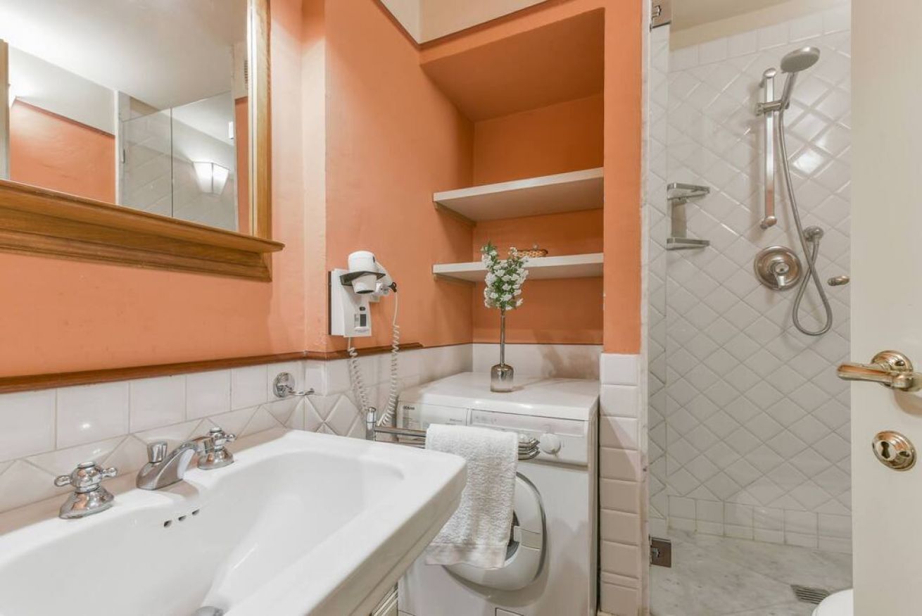 Un baño con lavamanos, inodoro y ducha.