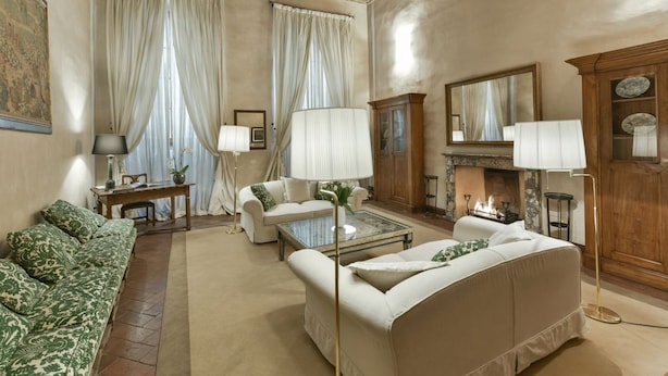 A spacious living room with a fireplace, two sofas, a coffee table, and a floor lamp. - Raffaello large apartment with fireplace in Oltrarno (Firenze)