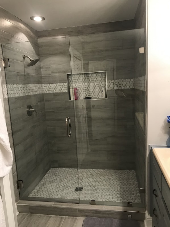 Een bad/douchecombinatie, een haardroger, handdoeken, zeep
