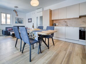 Eine moderne Küche mit weißen Schränken, einer Holz Arbeitsplatte und einem eingebauten Backofen.