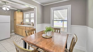 A kitchen with wooden cabinets, a white refrigerator, and a dining table with chairs. - Cozy Cottage Near Dtwn Dining, Walk to Casino (Bristol)