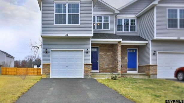 A two-story residential house with a garage, a blue front door, and a stone accent wall. - Home away from home! Entire townhome- large backyard. Close to many colleges.  (Troy)