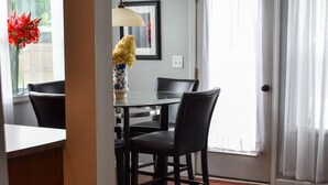 A dining area with a table and chairs, a vase with flowers, and a window with curtains. - Home away from home! Entire townhome- large backyard. Close to many colleges.  (Troy)