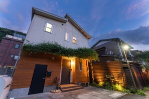 A modern two-story house with a wooden facade, a black door, and a small front porch. - Hakoneso (Hakone)
