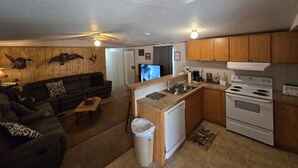 A compact living space with a kitchenette, a sofa, and a dining area. - Come and relax at the Refuge at beautiful Reelfoot Lake! (Hornbeak)