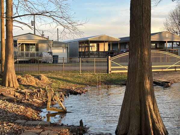 Un quartier résidentiel avec des maisons, une entrée sécurisée et un petit ruisseau.