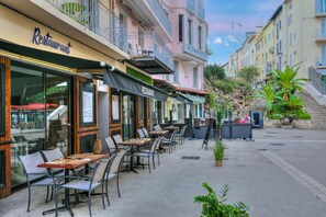 Ein Restaurant mit Außenbereich, einer Steinstufenanlage und Blick auf die Straße.