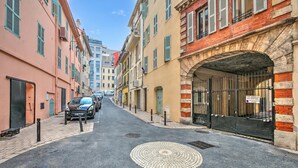 A narrow street lined with multi-story buildings, a parked car, and a manhole cover. - Au Vieux Port Cannes City Center, Cannes, France (Cannes)