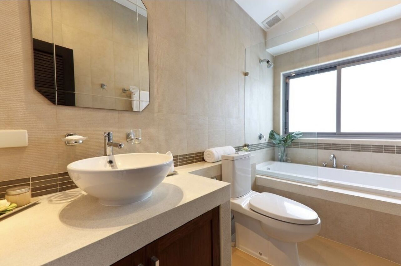 Un baño moderno con un lavamanos grande de color blanco, un inodoro y una bañera.