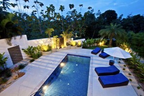 A rectangular swimming pool with a tiled floor, surrounded by lounge chairs and a small umbrella. - Stunning 3 Bedroom Pool Villa SDV040-By Samui Dream Villas (Koh Samui)