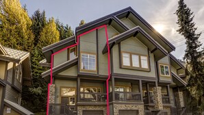 A multi-story house with a stone facade, multiple balconies, and a garage. - Snowy Creek 14 - True Ski in Ski out, easy walk to Whistler Village, Private Garage. (Whistler)