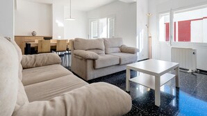 Un soggiorno moderno con divano, tavolino da caffè e zona pranzo con mobili in legno.