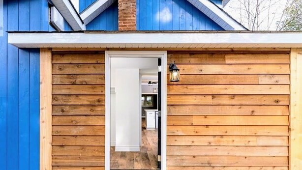 A wooden exterior with a blue door and a small light fixture. - Top 5% • 3BR Gem • Prime Location, Special Backyard, Great Hosts  (Huntsville)