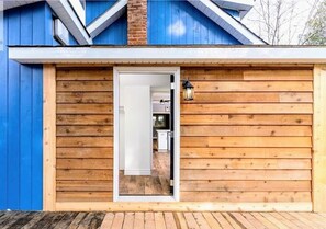 A wooden exterior with a blue door and a small light fixture. - Top 5% • 3BR Gem • Prime Location, Special Backyard, Great Hosts  (Huntsville)