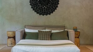 A bed with a headboard, pillows, and a blanket. - Terasu Riviera Maya Hotel & Spa Luxury Edition, en Xcaret (Playa del Carmen)