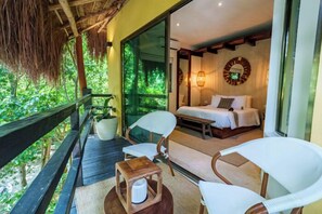 A room with a bed, two chairs, a small table, a potted plant, and a large window with a view of greenery. - Terasu Riviera Maya Hotel & Spa Luxury Edition, en Xcaret (Playa del Carmen)