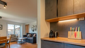 A modern kitchen with dark cabinets, a wooden countertop, and a knife block. - Small, charming, centrally located and yet quiet (Bad Hofgastein)