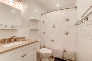 Een bad/douchecombinatie, handdoeken