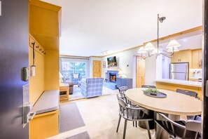 A modern kitchen with a dining area, a fireplace, and a view of the outdoors.