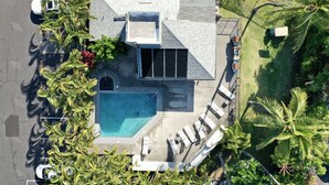 Vista aérea de una casa con piscina, porche cubierto y cochera.