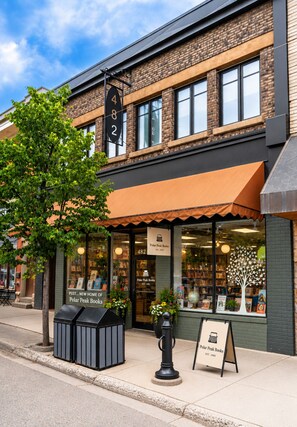 A bookstore with a brick facade, large windows, and a sign indicating its address. - Downtown Fernie Family Loft | 2BR + Gear Garage (Fernie)