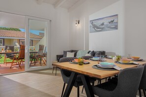 Ein Essbereich mit Holztisch, Stühlen und einem Gemälde an der Wand.