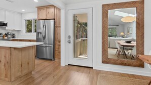 Una cocina moderna con gabinetes de madera, electrodomésticos de acero inoxidable y una isla grande.