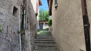 Un escalier étroit en pierre mène à un bâtiment à l’aspect rustique.