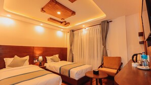 Une chambre d’hôtel avec deux lits, une petite table, une chaise et un décor de plafond en bois.