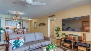 A living room with a sofa, coffee table, TV, and a dining area with chairs and a table. - Direct oceanfront resort offers great ocean views (Lahaina)