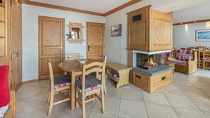 Um quarto aconchegante com móveis de madeira, lareira e uma mesa de jantar.