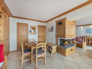 A cozy room with wooden furniture, a fireplace, and a dining table.