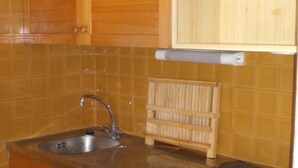 A kitchen with a sink, wooden cabinets, and a stove. - Studio cabin for 4 people, south-facing, balcony (Valloire)