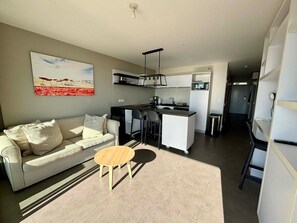 A modern apartment with a living area, kitchenette, and a dining area. - Stunning apartment for 6 with balcony, heated pool and direct beach access in La Tranche (La Tranche-sur-Mer)