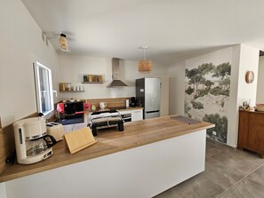 Eine moderne Küche mit Kochinsel, Backofen und Kühlschrank.