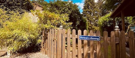 Une porte en bois, sur laquelle est apposée une pancarte indiquant « Ferienwohnung », mène à un chemin pavé.