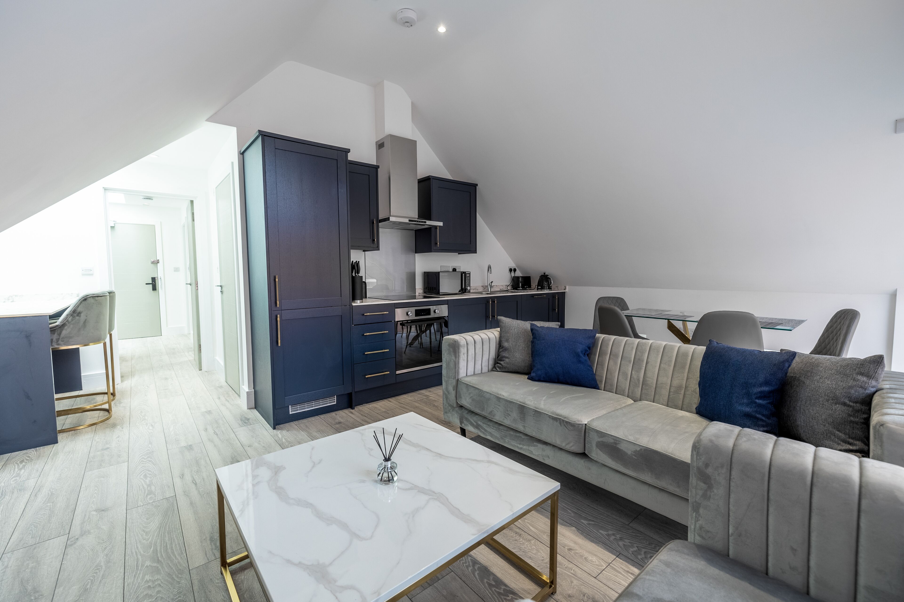A modern loft apartment with a kitchen, dining area, and living room.