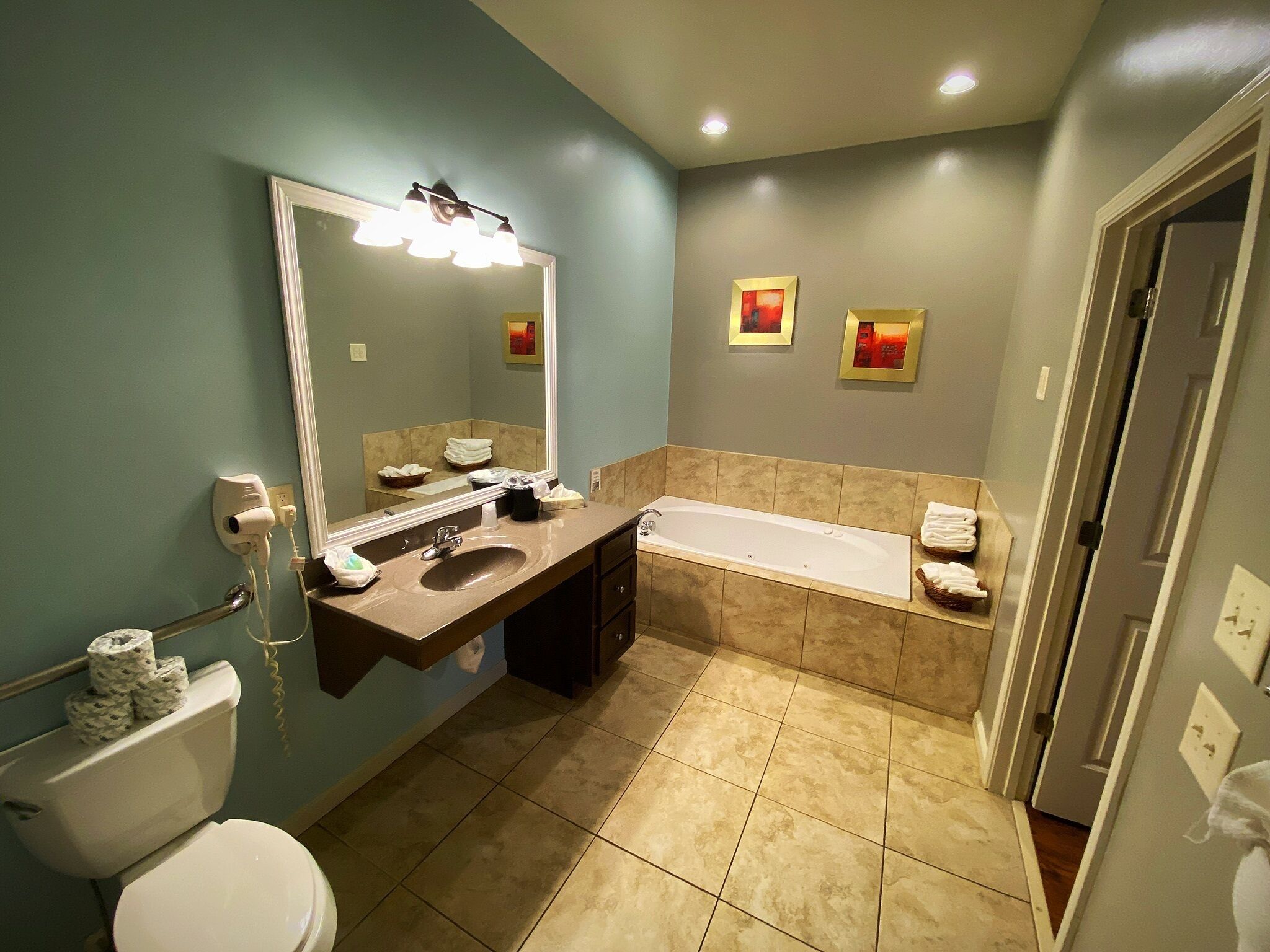 A bathroom with a sink, mirror, toilet, and bathtub.