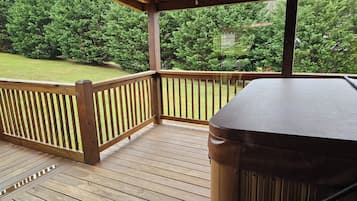 Eine Holzterrasse mit überdachtem Bereich und einem Whirlpool.