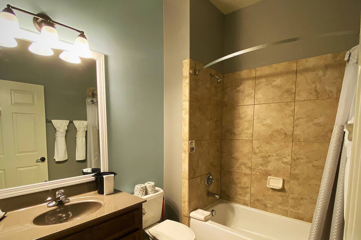 A bathroom with a sink, toilet, and bathtub.