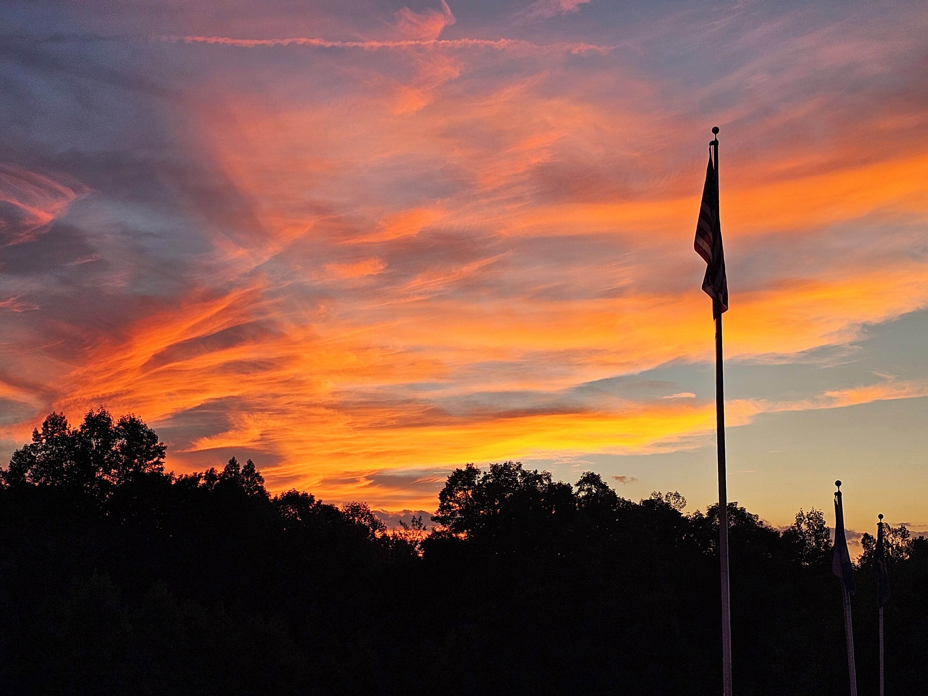 Un asta de bandera contra un cielo al atardecer.