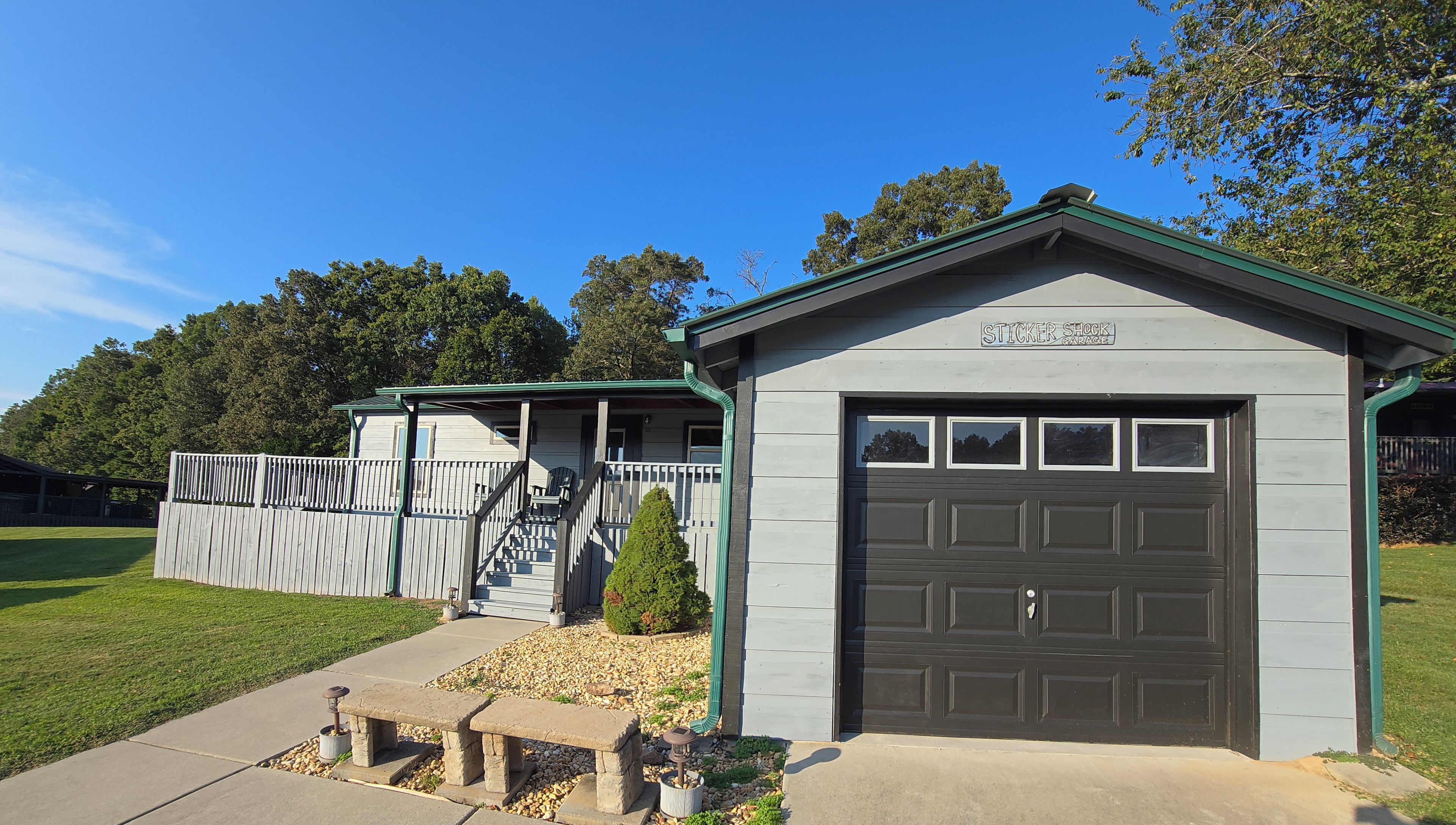 Une maison à deux étages avec un garage sur lequel est apposé un autocollant indiquant : « Sticker Shock Garage ».
