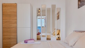 Ein Hotelzimmer mit Bett, Schrank, Spiegel und Meerblick.