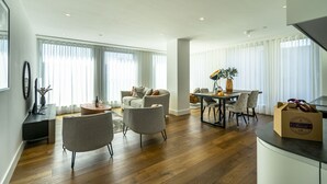 A modern living room with a sofa, armchairs, a dining table, and a coffee table. - A premium stay that sleeps 5 guests  in 2 bedrooms (York)