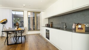 A modern kitchen with white cabinets, a black countertop, and a built-in oven. - A premium stay that sleeps 5 guests  in 2 bedrooms (York)