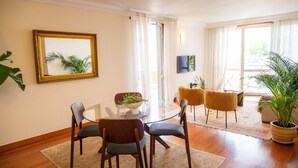 A dining area with a glass table, chairs, and a large mirror on the wall. - Madeira Precious Penthouse (Funchal)