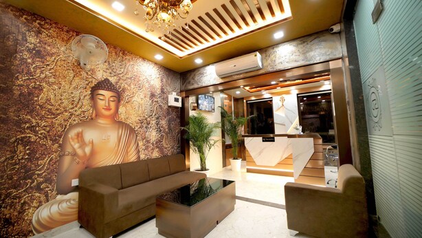 A lobby with a Buddha mural, a reception desk, and a modern seating area. - Hotel SD Prime (Jaipur)