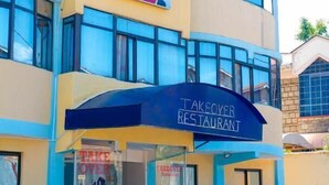 A multi-story building with a 'TAKEOVER RESTAURANT' sign on the facade. - Takeover Restaurant & Accommodation (Kisumu)