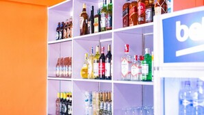 A liquor store with shelves stocked with various bottles and glasses. - Takeover Restaurant & Accommodation (Kisumu)